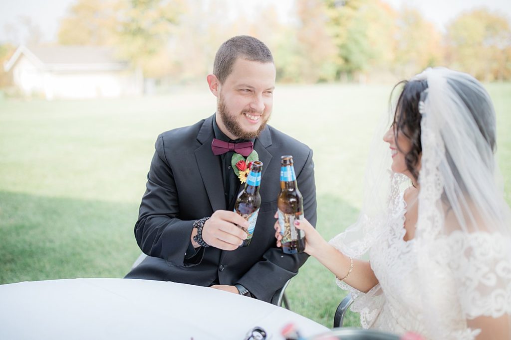 bride and groom toasting with beer