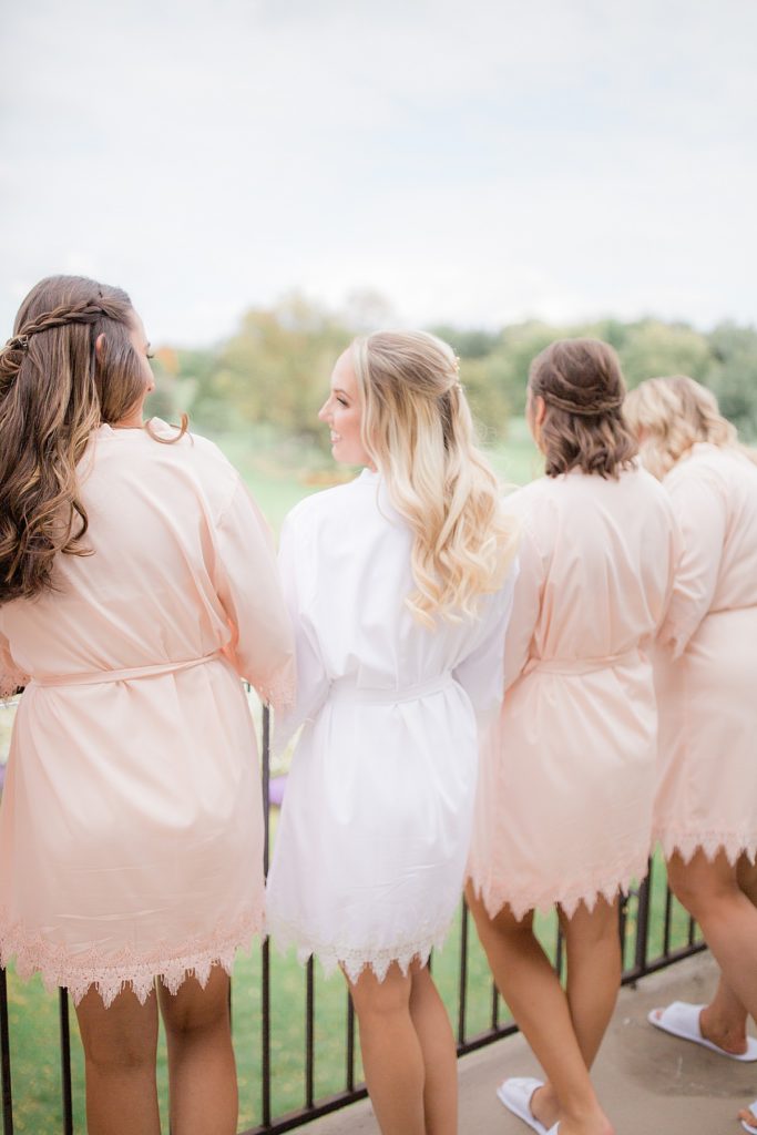 bride and bridesmaids standing on a terrace in their robes