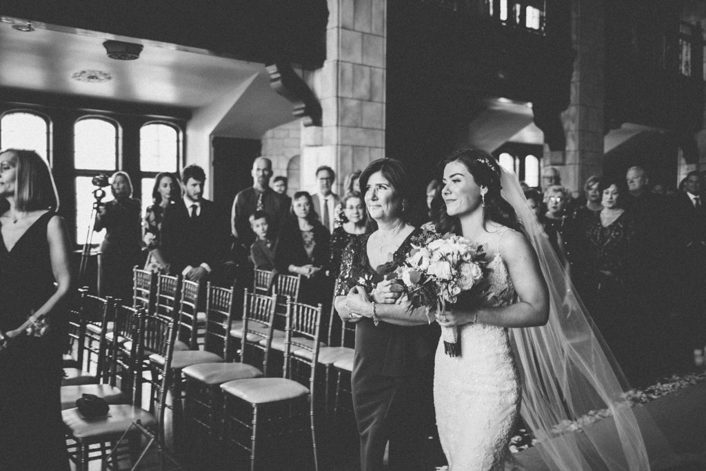 bride and mom walk down the aisle