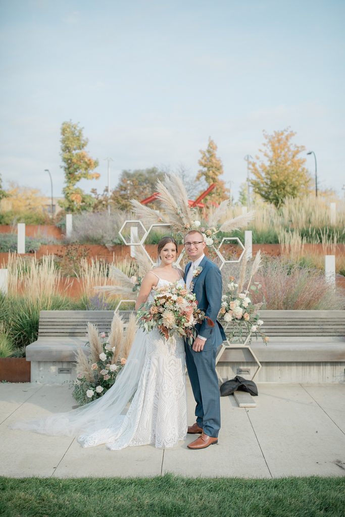 bride and groom in front of ceremony arch at akron art museum