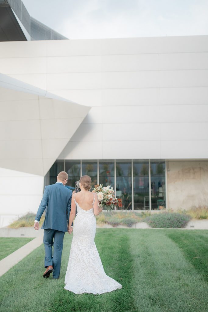 bride and groom walk toward the art museum