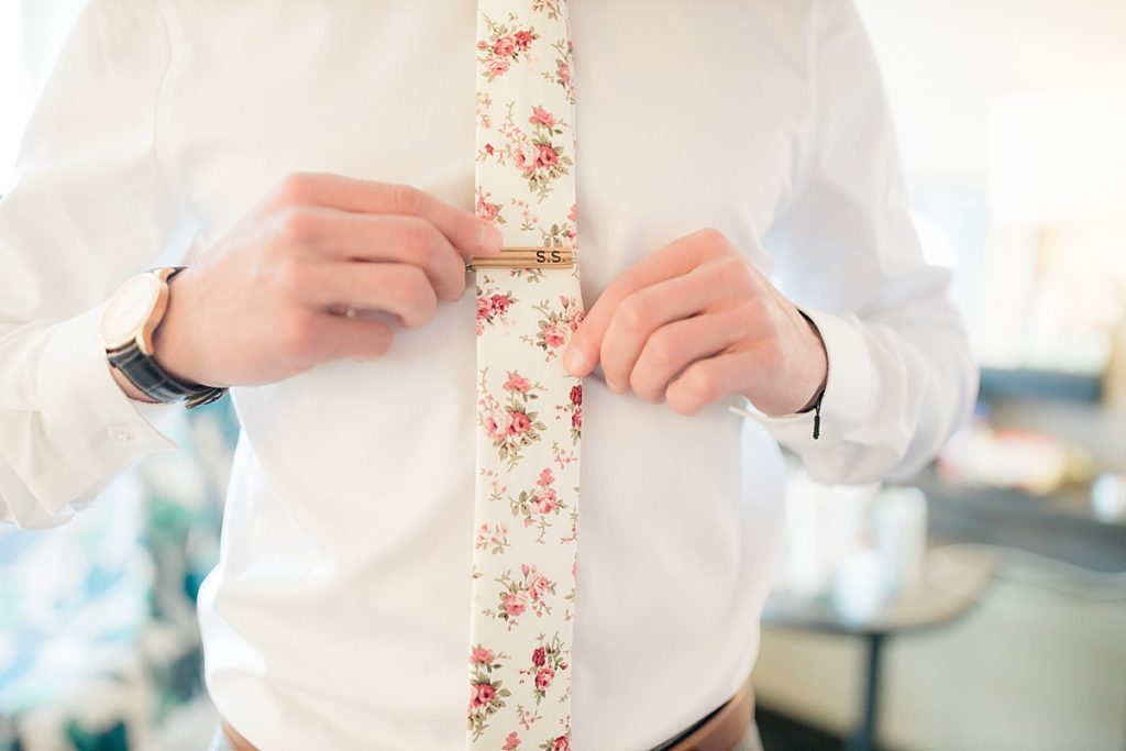 closeup on groom's tie and tie clip