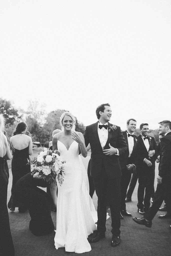 bride and groom laughing with their friends