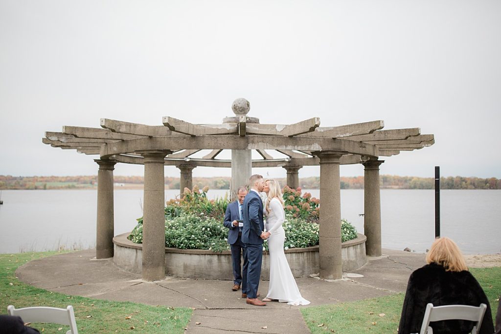 bride and groom kiss overlooking chippewa lake