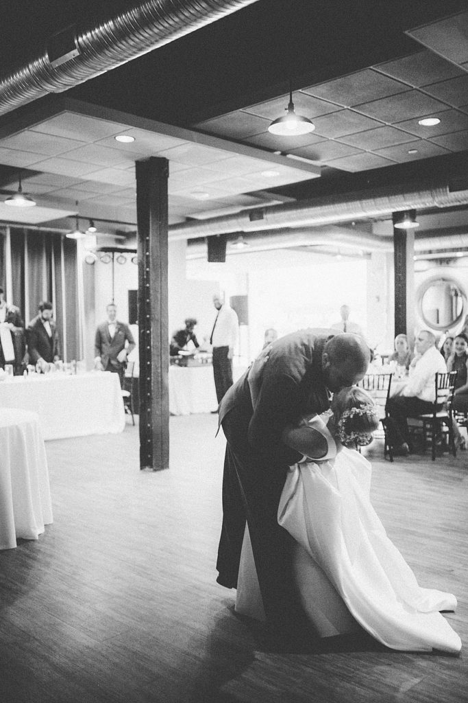 Groom dips bride into a kiss on the dance floor