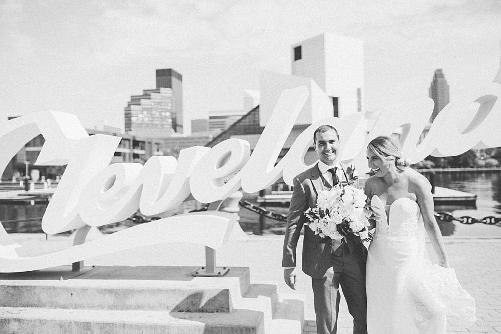 bride and groom at the CLE sign