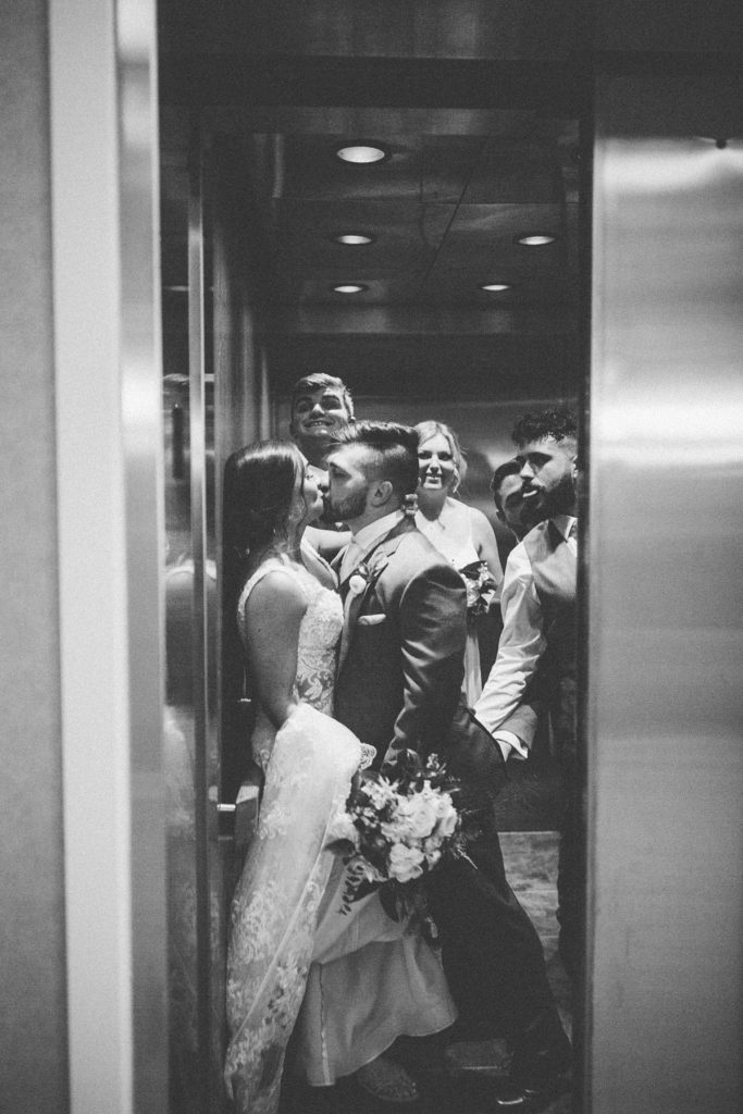 bride and groom kiss in the elevator