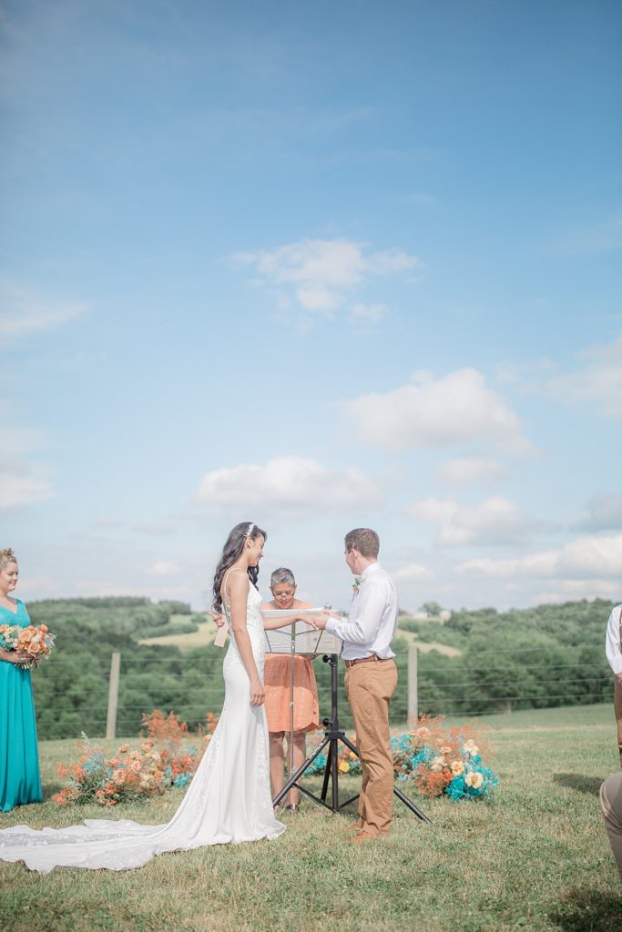 bride and groom exchanging rings during their outdoor ceremony