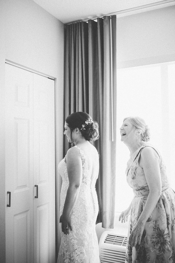 bride and mom laughing as they get ready