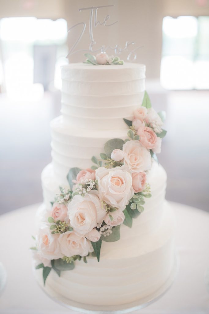 front side of the wedding cake with florals and white icint