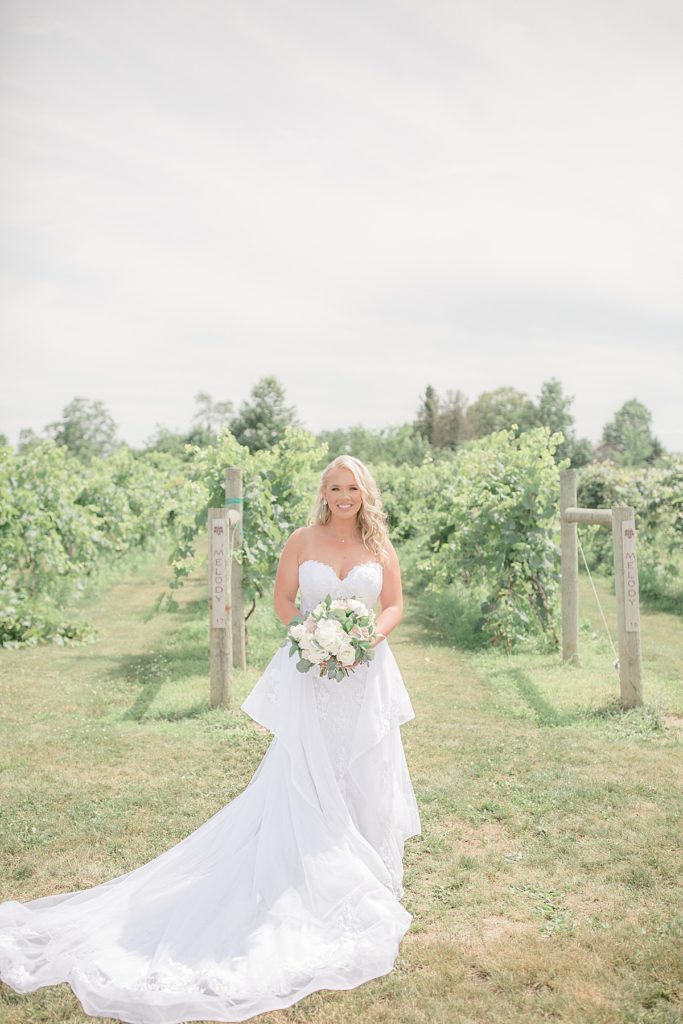bride smiling in front of the vineyards