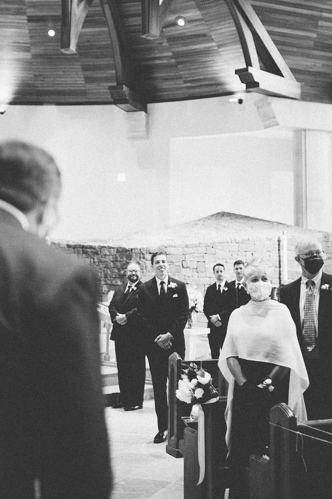 groom watching the bride walk down the aisle