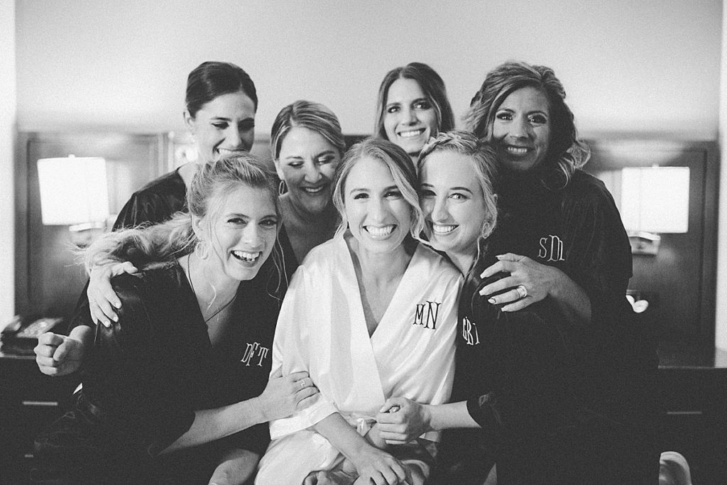 bride and bridesmaids hugging in their robes